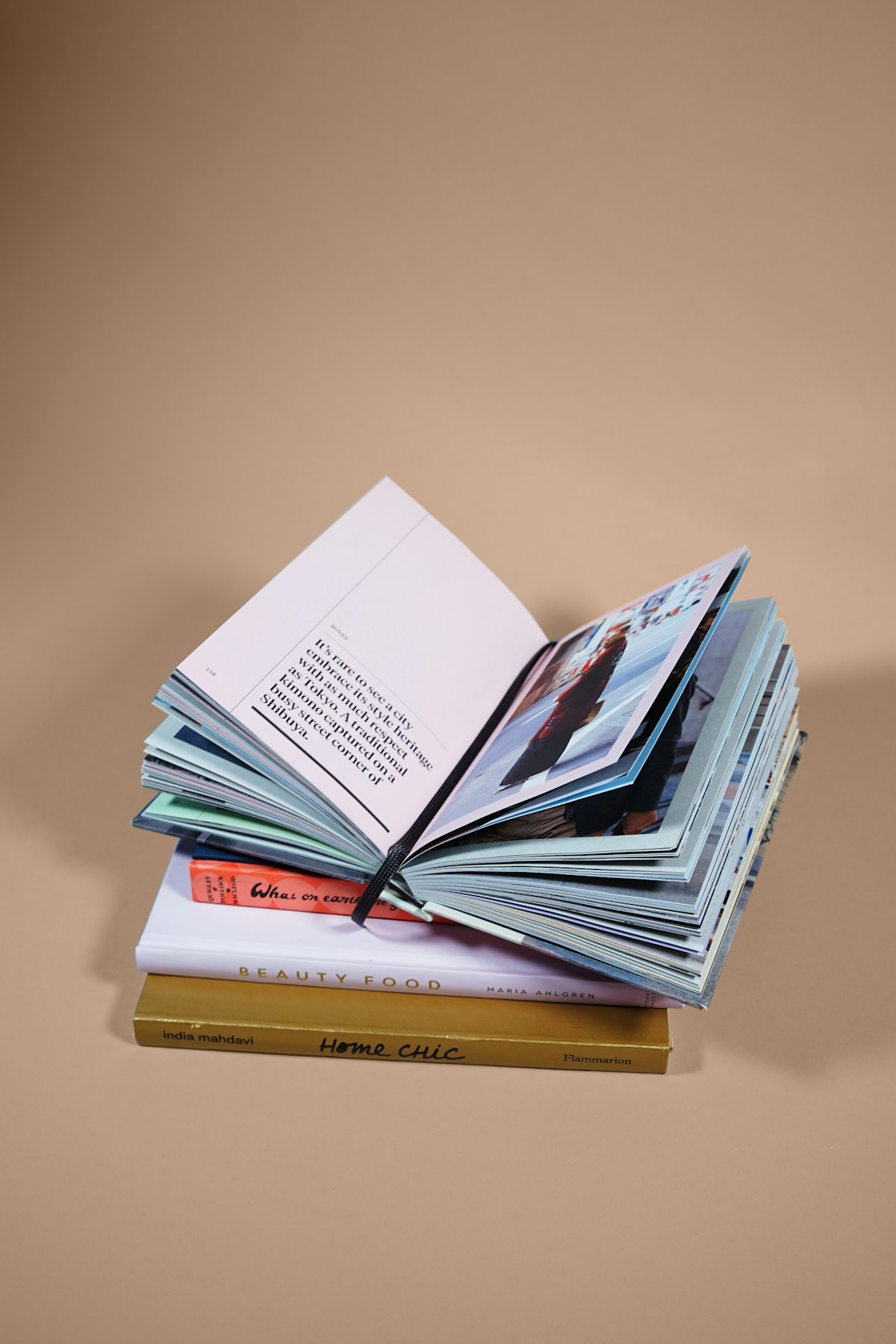 Livre à couverture rigide debout légèrement ouvert montrant son dos et l'épaisseur des plats, à côté d'un livre couché à couverture bleue