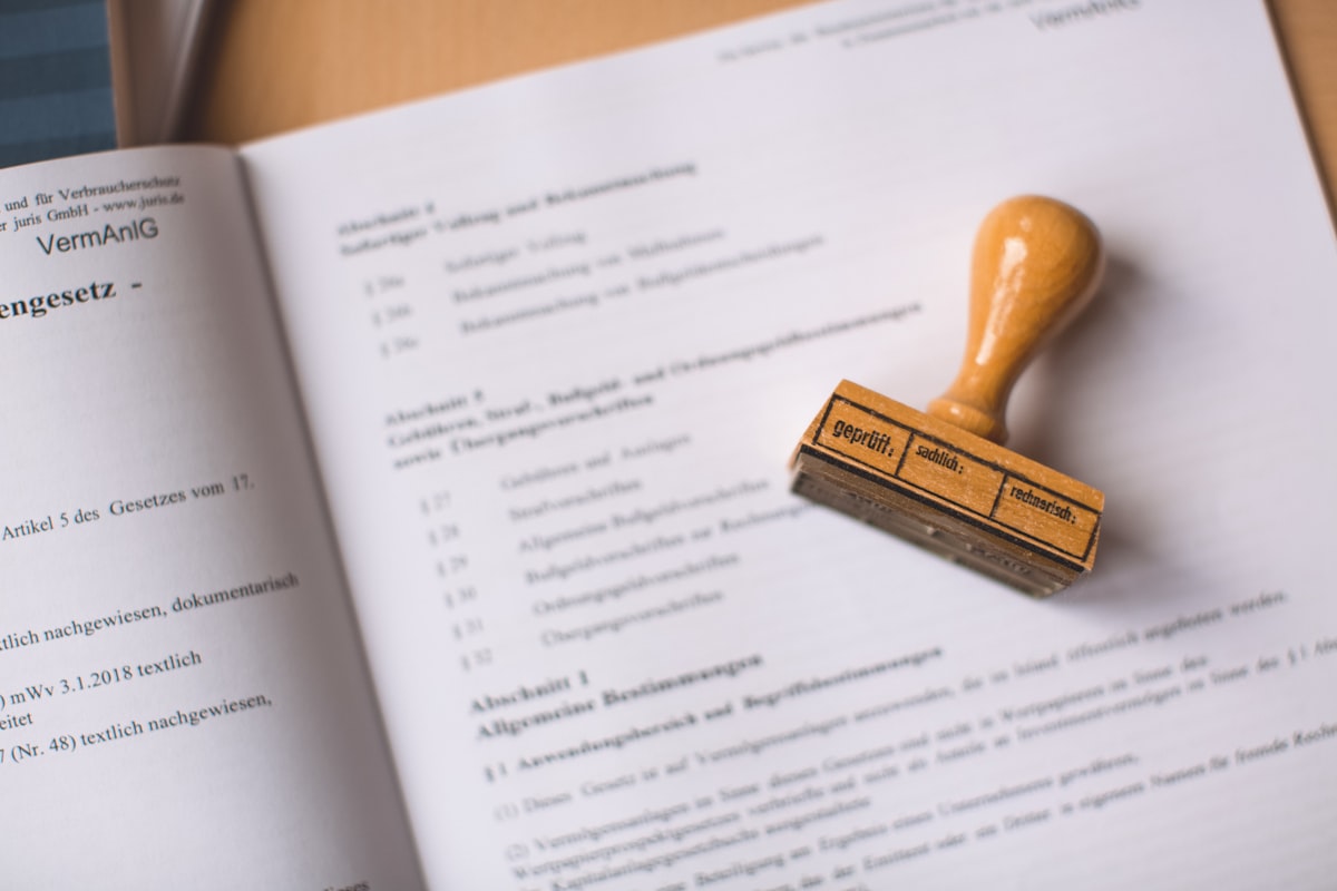 Tampon encreur automatique imprimant une empreinte personnalisée sur un document, accompagné d'un tampon bois et d'une plaque texte de rechange gravée